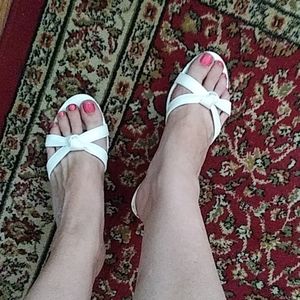 White slip on sandals with 1.5 inch heal.